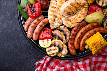 Grilled sausages, meat, and vegetables.