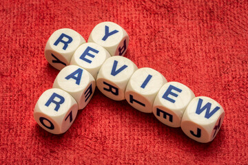 year review crossword in letter dices against textured handmade paper, annual business summary and analysis concept