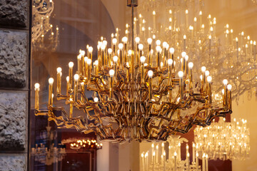 Expensive luxury large chandelier behind glass with gilding.