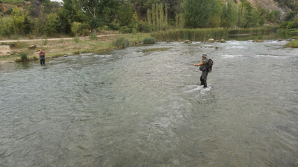 Personas pescando en el rio con ca&ntilde;a