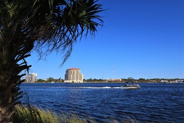 USA, Florida, Photo taken from Santa Rose Island - October 2020. Speedboat sails on the water of Santa Rosa Sound. The mainland coast is visible in the background