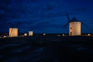 Fototapeta premium Exterior view of windmills on landscape in spring in Campo de Criptana at dusk, Ciudad Real, Spain