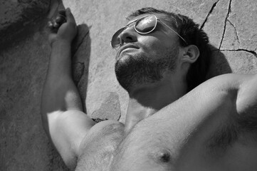 Man lying in the sun on slab 