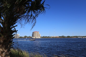 USA, Florida, Photo taken from Santa Rose Island - October 2020. Speedboat sails on the water of Santa Rosa Sound. The mainland coast is visible in the background