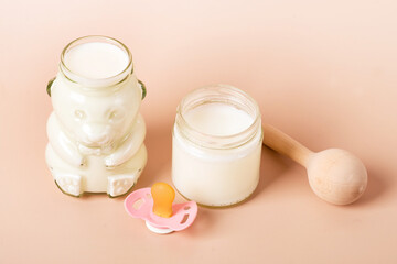 Obraz na płótnie Canvas baby milk in a jar for newborns on a beige background.