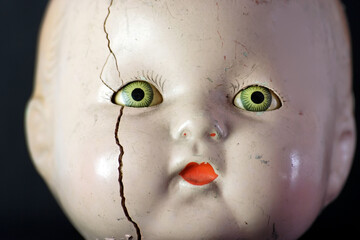 Creepy doll head with spooky green eyes.