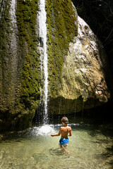Boy playing in waterfall