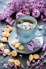Fototapeta na wymiar Still life with lilac flowers and tea with cookies