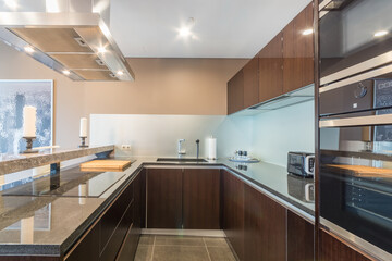 Modern kitchen with a marble counter, equipped with cooker, oven, fridge