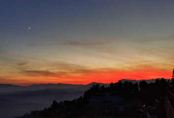Tramonto sulle montagne, colline e valli dell'Appennino con la luna nel cielo