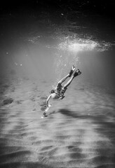 Obraz na płótnie Canvas Young boy swimming underwater