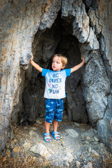 Boy standing below rock formation