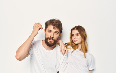 Cute young couple in white t-shirts and jeans hug emotions isolated background