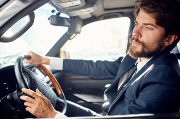 business man in suit driving a car trip luxury road