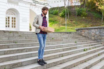 Office worker with a box of things, leaves work. The businessman lost his job due to the economic crisis. Unemployment and layoffs concept