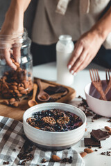 Ideas for an autumn winter breakfast. Spicy yoghurt with granola, dried berries, nuts, almonds, spices (cinnamon, anise), in cup, plate.