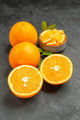 Vertical view of set of yellow whole and cut lemons on dark background