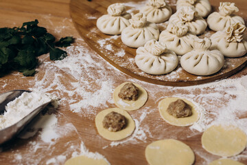 National Georgian cuisine. Khinkali with meat. Khinkali on a wooden background. Preparation process