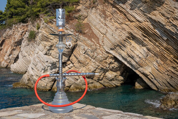 Hookah on the background of the blue sea and rocks.
