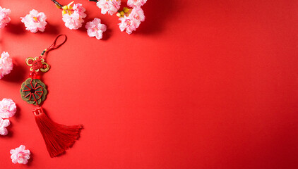 Chinese new year festival decorations made from chinese good luck symbol and plum blossom on a red background.  Flat lay, top view with space.