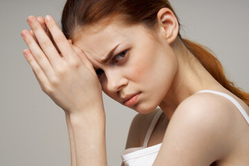 Naklejka premium woman holding joined hands near face white t-shirt side view headache