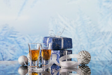 Two glasses of whiskey or bourbon with Christmas decoration on a light bokeh background. New Year, Christmas and winter holidays whiskey mood concept