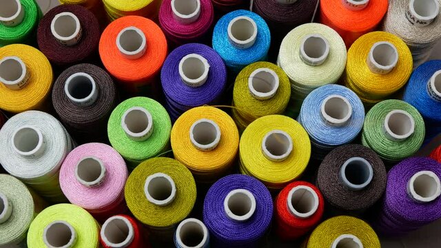 Background of multicolored spools of thread for a sewing machine and overlock, Top view