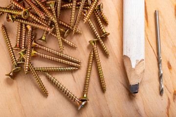 Metal wood screws and a carpenter's pencil. Minor carpentry work in the workshop.