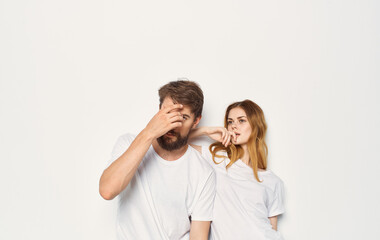 Cute young couple in white t-shirts and jeans hug emotions isolated background