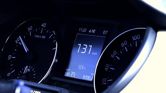 Close-up macro 4K UHD footage of car dashboard with speedometer showing 130 speed during driving - blue business colorcast
