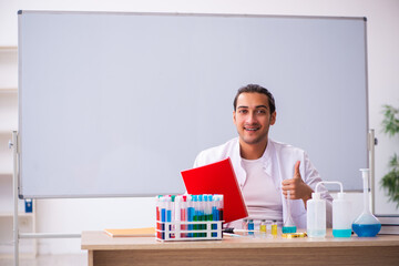 Young male chemistry teacher in the classroom