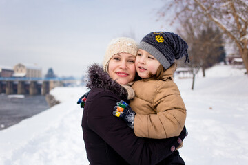 Mom and son in winter clothing hugging