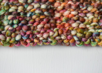 background of colourful hand knitting pattern with white copy space 