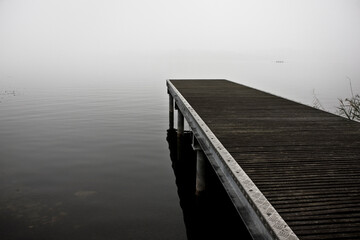 Desolate pier shrouded in fog - Emotional picture taken near to a lake on a gloomy day