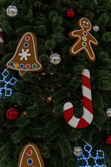 Close up of big Christmas tree with different christmas toys in shopping center. Coniferous tree with decorative adornments to create festive mood during holiday celebration.