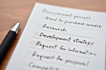 The checklist with "Procurement Process" written on it. It is focus on "Development Strategy".