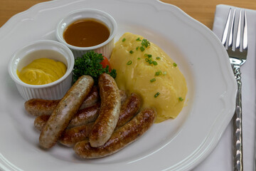 Six Bavarian grilled Nuremberg sausages served with potato mash, dark beer jus and mustard
