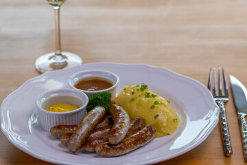 Six Bavarian grilled Nuremberg sausages served with potato mash, dark beer jus and mustard