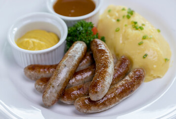 Six Bavarian grilled Nuremberg sausages served with potato mash, dark beer jus and mustard