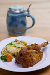 Grilled half chicken served with German potato cucumber salad with bacon