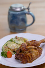 Grilled half chicken served with German potato cucumber salad with bacon