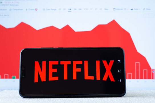 Netflix logo on the smartphone screen and the chart with share (NFLX) price for the last month at the blurred background. Netflix stock falls again.