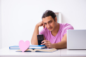 Male student in love preparing for exams at home