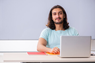 Young male student preparing for exams in tele-education concept