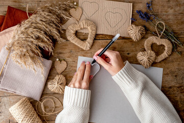 Zero waste Valentine's Day concept and mock up. Female hands drow stencil heart. Top view or...