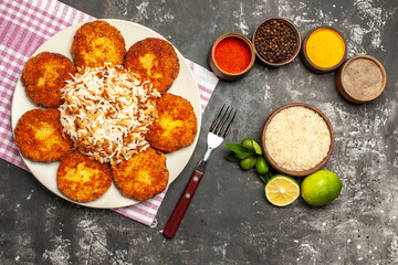 top view tasty fried cutlets with rice and seasonings on the dark background meat rissole food