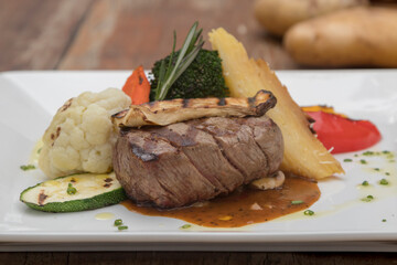 Chargrilled beef tenderloin with mixed vegetables, potato gratin mushroom sauce