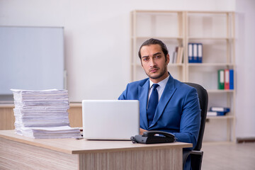Young male employee and too much work in the office