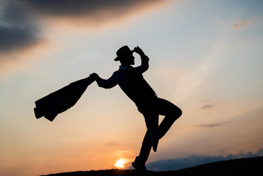 silhouette of male dancer dance in sense of freedom on sunrise sky, inspiration