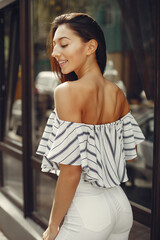 Beautiful girl in a city. Stylish girl in a white blouse